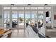 Open living room with large windows offering waterfront views, including pool, outdoor furniture, and palm trees at 553 Old Compass Rd, Daniel Island, SC 29492