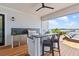 Well-equipped outdoor kitchen featuring a stainless steel grill, bar seating, and scenic views at 553 Old Compass Rd, Daniel Island, SC 29492