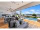Covered outdoor area featuring a full kitchen, dining table, lounge chairs, and pool with scenic water view at 553 Old Compass Rd, Daniel Island, SC 29492