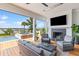 Outdoor patio with fireplace, TV, and a view of the pool, waterway, and palm trees at 553 Old Compass Rd, Daniel Island, SC 29492