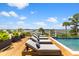Relaxing lounge chairs by the pool overlooking beautiful waterfront scenery and a clear blue sky at 553 Old Compass Rd, Daniel Island, SC 29492