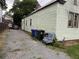 Exterior view of a two-story home with trash receptacles and a gravel driveway at 6 Orrs Ct, Charleston, SC 29403