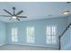 Spacious bedroom with plush carpeting, ceiling fan, three windows, and staircase access at 765 Certificate Ct, Charleston, SC 29414