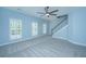 Carpeted bedroom featuring a ceiling fan, and staircase with natural lighting through three large windows at 765 Certificate Ct, Charleston, SC 29414