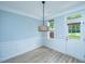 Dining area features a stylish pendant light fixture, light blue walls, and access to backyard at 765 Certificate Ct, Charleston, SC 29414