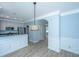 Open dining area showcasing adjacent kitchen, modern light fixture, and white wainscoting at 765 Certificate Ct, Charleston, SC 29414
