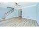 Living room with light blue walls, light wood floors, ceiling fan, staircase, and neutral decor at 765 Certificate Ct, Charleston, SC 29414