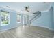 Bright living room with blue walls, light wood floors, staircase, ceiling fan and an inviting atmosphere at 765 Certificate Ct, Charleston, SC 29414