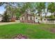 All brick home with green lawn, picket fence, and mature trees providing shade at 10 Teaneck Rd, Goose Creek, SC 29445