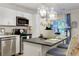 Bright kitchen featuring white cabinets, stainless steel appliances, and a dark countertop island with seating at 10 Teaneck Rd, Goose Creek, SC 29445