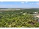 Breathtaking aerial perspective of the property immersed in a dense forest close to the green golf course at 1025 Scaup Ct, Kiawah Island, SC 29455