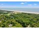 Panoramic aerial view showcasing the home nestled within a lush, green neighborhood near the sandy beach at 1025 Scaup Ct, Kiawah Island, SC 29455