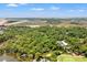 Aerial view of area featuring lush green forest, golf course, and water, creating a serene landscape at 1025 Scaup Ct, Kiawah Island, SC 29455