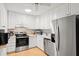 Well-lit kitchen features white cabinets, stainless steel appliances, and tiled backsplash at 1025 Scaup Ct, Kiawah Island, SC 29455