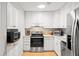 Well-lit kitchen features white cabinets, stainless steel appliances, and tiled backsplash at 1025 Scaup Ct, Kiawah Island, SC 29455