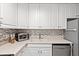 Bright kitchen featuring white cabinetry, modern appliances, and tiled backsplash at 1025 Scaup Ct, Kiawah Island, SC 29455