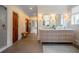 Elegant bathroom with dual sinks, stylish mirrors, gold sconces, and a seamless glass-enclosed shower at 108 Live Oak Dr, Mount Pleasant, SC 29464