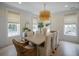 Elegant dining room featuring a rustic wood table, stylish chandelier, and ample natural light at 108 Live Oak Dr, Mount Pleasant, SC 29464