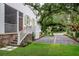 Long driveway leading to the house with manicured landscaping, brick details, and a large shade tree at 108 Live Oak Dr, Mount Pleasant, SC 29464