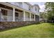 Classic home exterior with a brick foundation, white siding, a screened-in porch, and a well-manicured lawn at 108 Live Oak Dr, Mount Pleasant, SC 29464