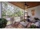 Charming porch featuring wicker chairs, an outdoor ceiling fan, a concrete table, and a view of the lush yard at 108 Live Oak Dr, Mount Pleasant, SC 29464