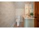 Stylish powder room featuring unique wallpaper, a marble vanity with gold fixtures, and an elegant aesthetic at 108 Live Oak Dr, Mount Pleasant, SC 29464