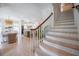 Staircase with wood handrail and views of the breakfast nook and kitchen, seamlessly connecting the home's spaces at 108 Live Oak Dr, Mount Pleasant, SC 29464