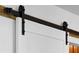 Close up of black hardware for a white, sliding barn door inside of a home at 108 Plume Poppy Ln, Ladson, SC 29456