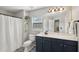 Bathroom with a large mirror, blue vanity, patterned tile floors, and shower at 108 Plume Poppy Ln, Ladson, SC 29456