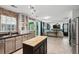 Open concept kitchen with brick accents, island, and modern appliances leading to a spacious living area at 108 Plume Poppy Ln, Ladson, SC 29456