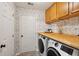 Well-lit laundry room with wooden countertop, modern appliances, and stylish wallpaper at 108 Plume Poppy Ln, Ladson, SC 29456
