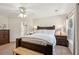 Spacious main bedroom with a wood bed frame, soft carpet, and a connecting ensuite bathroom at 108 Plume Poppy Ln, Ladson, SC 29456