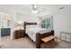 Spacious main bedroom featuring a wood bed frame, bench, ceiling fan, and large window at 108 Plume Poppy Ln, Ladson, SC 29456