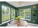 A bright sunroom featuring lots of natural light, green walls, tile floors, and a round dining table at 108 Plume Poppy Ln, Ladson, SC 29456