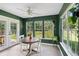 Bright sunroom with green walls, natural light, tile floors, and a round table for dining at 108 Plume Poppy Ln, Ladson, SC 29456