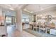 Elegant dining room featuring hardwood floors, decorative chandelier and wainscotting leading to open-concept floor plan at 113 Magnolia House Dr, Summerville, SC 29486