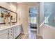 Elegant bathroom boasts a double vanity, decorative mirror, and doorway view to the primary bedroom at 120 Magnolia House Dr, Summerville, SC 29486