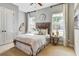 Bright bedroom featuring a rustic headboard, soft neutral tones, and natural light from two large windows at 120 Magnolia House Dr, Summerville, SC 29486