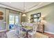 Dining area with sliding glass door to patio, decorated with lamps, buffet, and circular patterned mirror at 120 Magnolia House Dr, Summerville, SC 29486