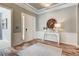 Elegant foyer with white wainscoting, decorative mirror, light hardwood floors, and a bright, welcoming ambiance at 120 Magnolia House Dr, Summerville, SC 29486