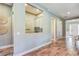 Hallway view leading to a bright home office and the front entrance, showcasing wood floors at 120 Magnolia House Dr, Summerville, SC 29486