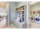 Welcoming mudroom equipped with a storage bench and adjacent laundry room with modern appliances at 120 Magnolia House Dr, Summerville, SC 29486