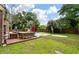 Inviting backyard with a sparkling pool, lush greenery, and an umbrella shaded seating area for relaxation and outdoor enjoyment at 129 Dunbury Dr, Summerville, SC 29485