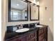 Bathroom featuring double sinks with black granite countertops and dark wood cabinetry at 129 Dunbury Dr, Summerville, SC 29485