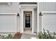 Inviting entryway featuring a black front door framed by white trim and sconce lighting at 134 Brown Swiss Cir, Summerville, SC 29483