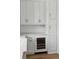 Elegant kitchen featuring white cabinets, marble countertops, and a built-in wine cooler at 1479 Jeremy Cay Ct, Awendaw, SC 29429