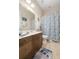 Bright bathroom featuring a wood vanity, framed mirror, and blue seashell-themed shower curtain at 1517 Willtown St, Charleston, SC 29492