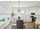 Elegant dining area with stylish light fixture, wood table, and large windows for natural light at 1801 Sandybrook Dr, Mount Pleasant, SC 29466