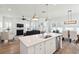 Bright, open-concept living room featuring a fireplace, wood floors, and island with stainless steel dishwasher at 1801 Sandybrook Dr, Mount Pleasant, SC 29466