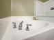 Close up view of a clean, white tiled soaking tub with chrome fixtures in the bathroom at 188 Donning Dr, Summerville, SC 29483